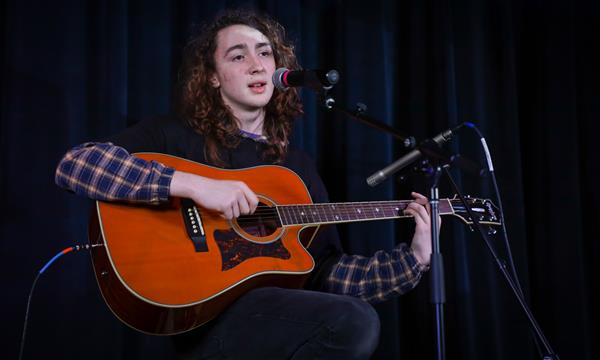 student plays a guitar